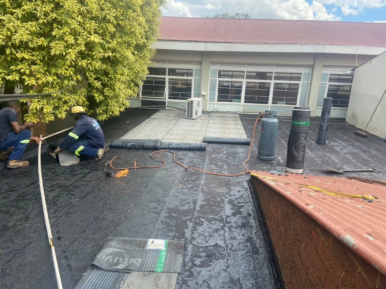 Team carrying out waterproofing work on a flat roof